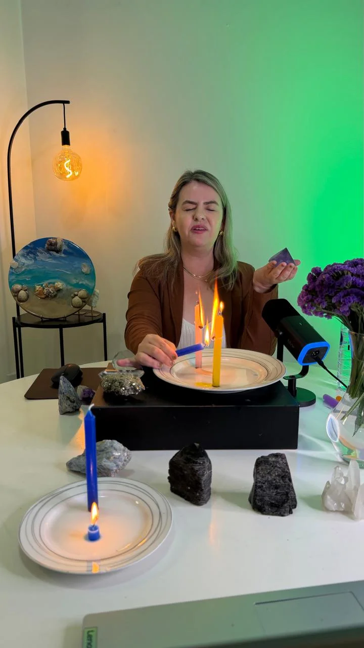 Andréia conduzindo um processo com velas e cristais